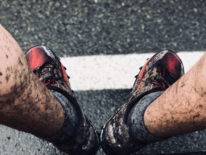 Low section of man with muddy legs on road