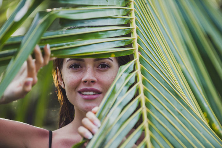 Portrait of woman holding palm leaf