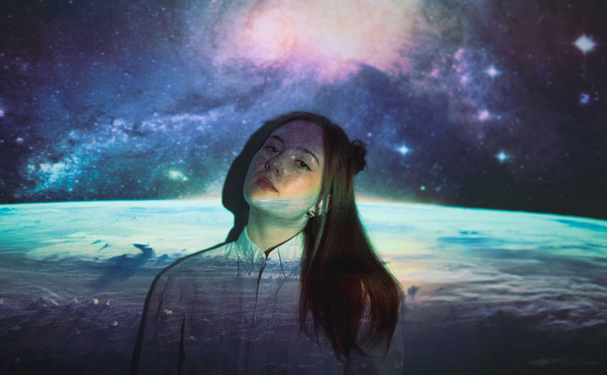 portrait of young woman looking away against sky