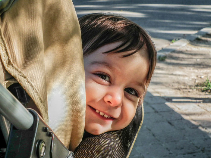 Close-up portrait of cute girl sitting in baby stroller