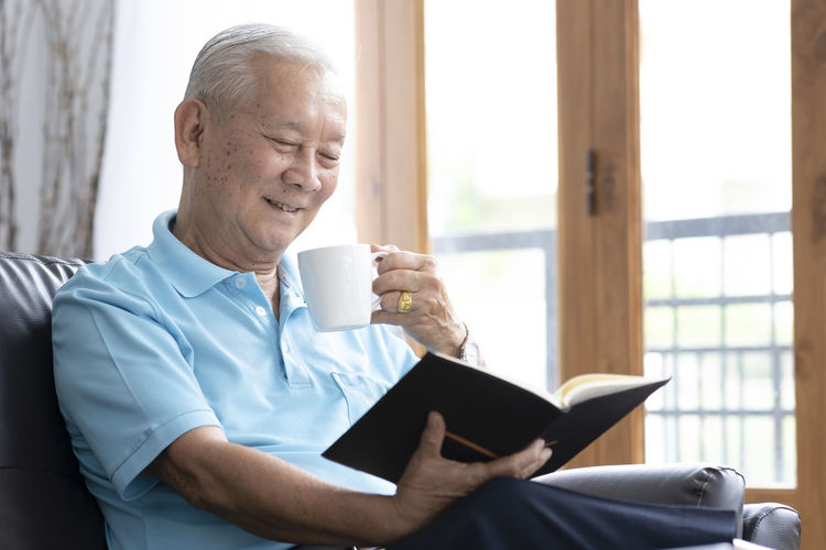 Man holding coffee cup sitting at home