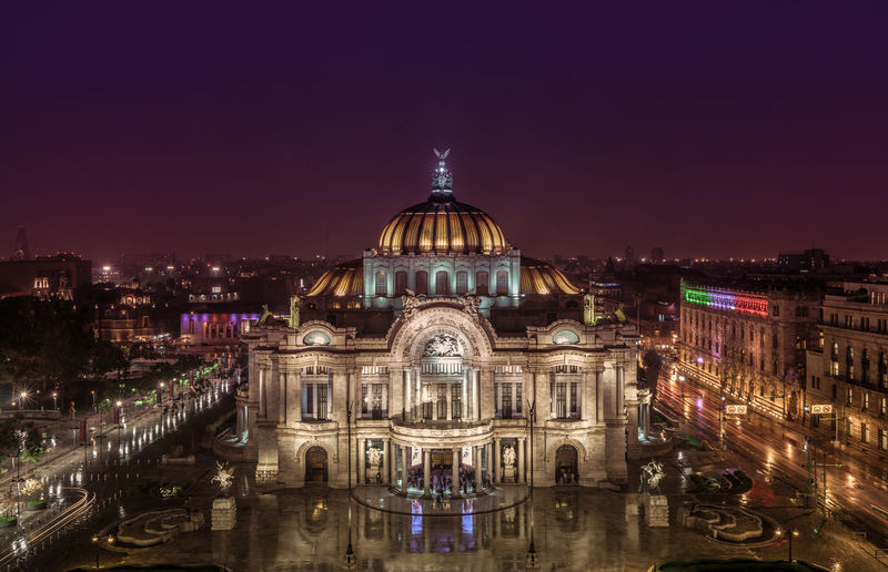 Illuminated palacio de bellas artes amidst city at night