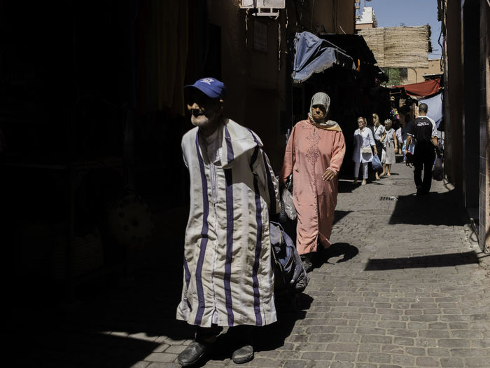 Rear view of women walking on street in city