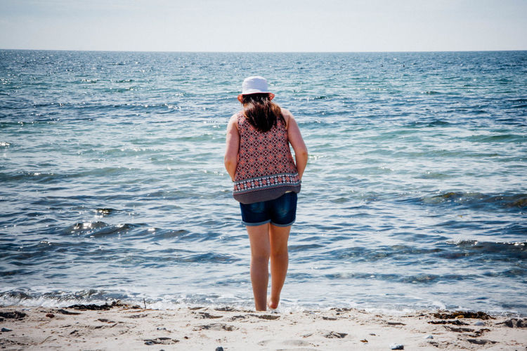 Rear view of woman standing at sea shore