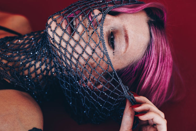 Close-up of beautiful young woman with net scarf