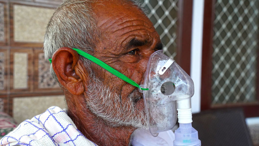 Close-up of man wearing oxygen mask