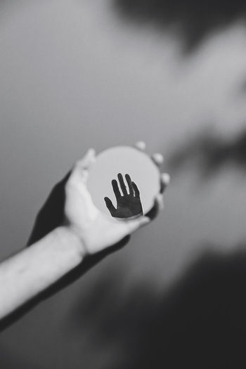 Close-up of person holding hand in a reflection 