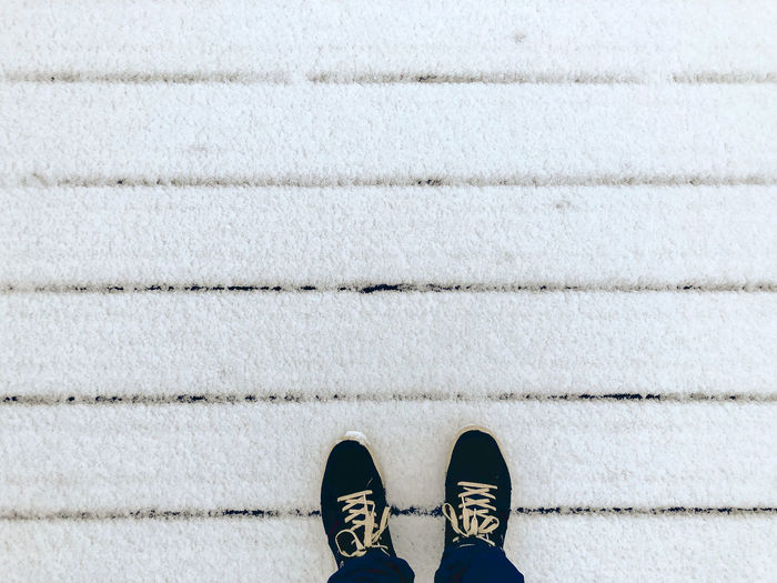 Low section of person standing on tiled floor