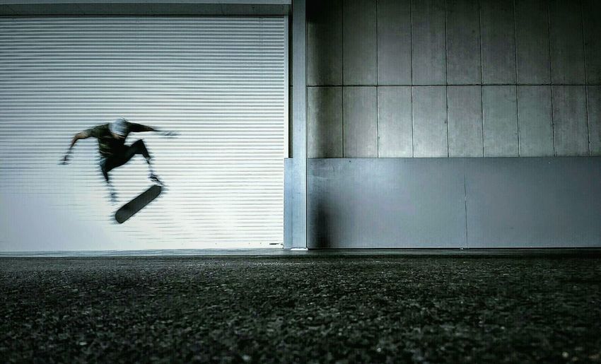 Man performing stunt on skateboard at night