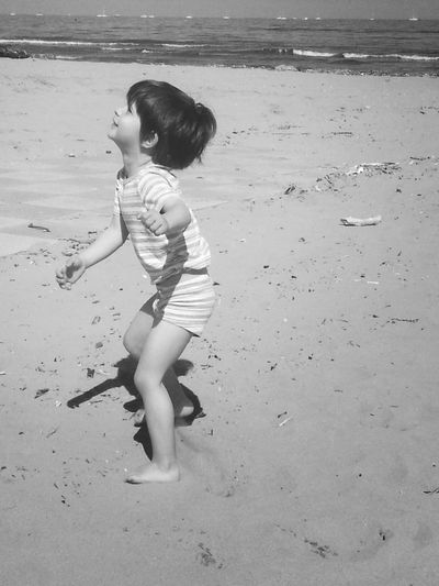 Girl playing at beach on sunny day
