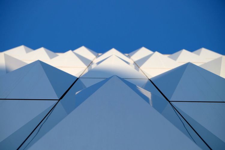 Low angle view of buildings against clear blue sky