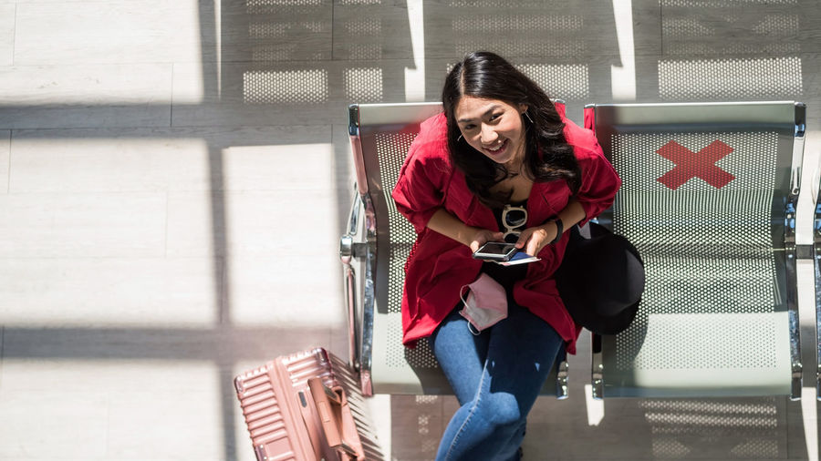 Portrait of young woman sitting on railing