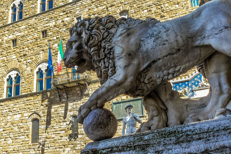 Low angle view of lion statue against historic building