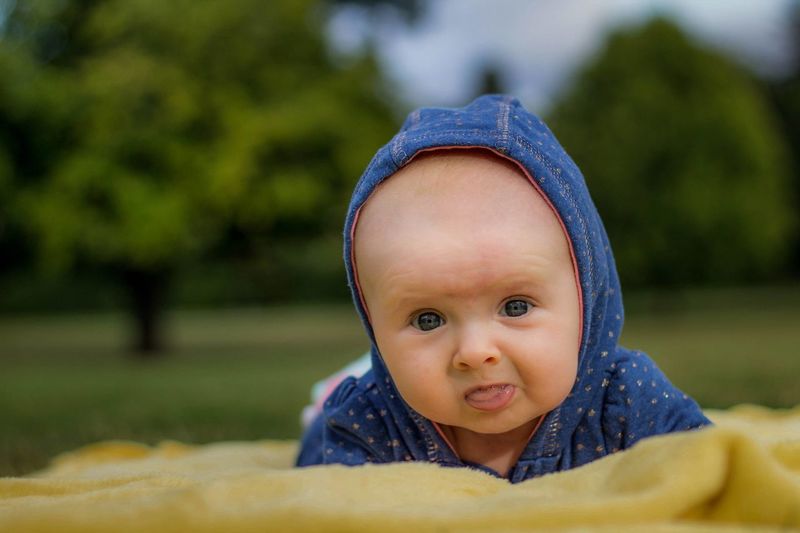 Portrait of cute baby girl on picnic blanket