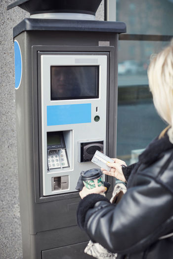 Woman using card to withdraw money from atm