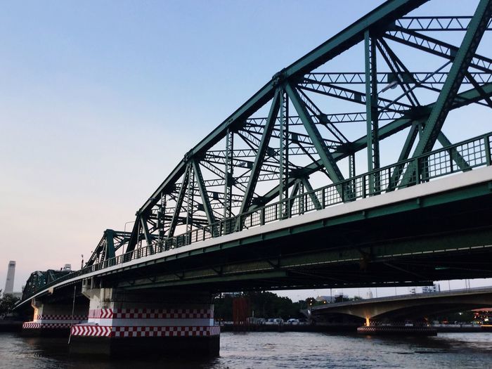 Memorial bridge over chao phraya river against sky in city
