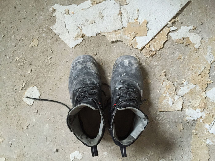 Low section of person standing on old shoes