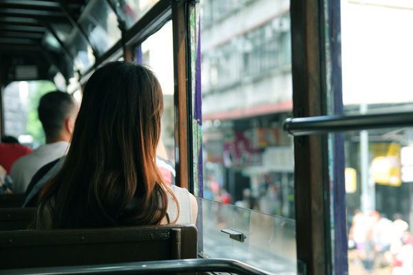 Rear view of man and woman sitting in bus by window