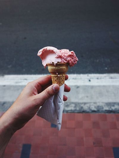 Close-up of cropped hand holding strawberry ice cream
