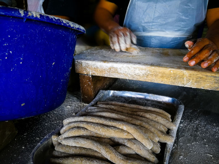 Unidentified hand is making a keropok lekor, a local delicacy made from fish and starch.