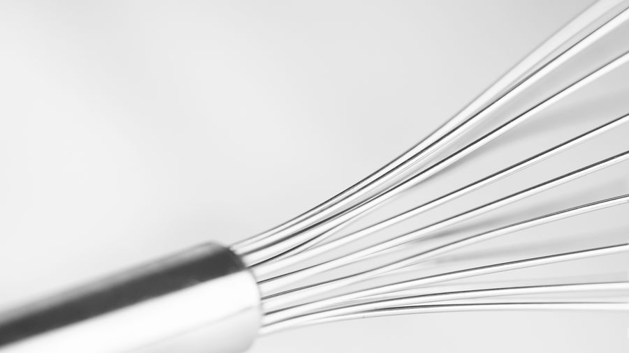 Cropped image of wire whisk against white background