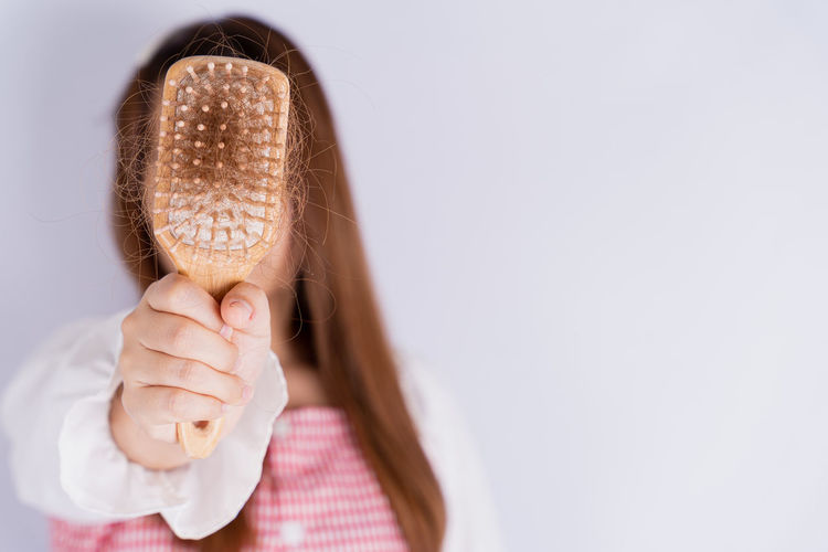 Midsection of woman holding ice cream over white background
