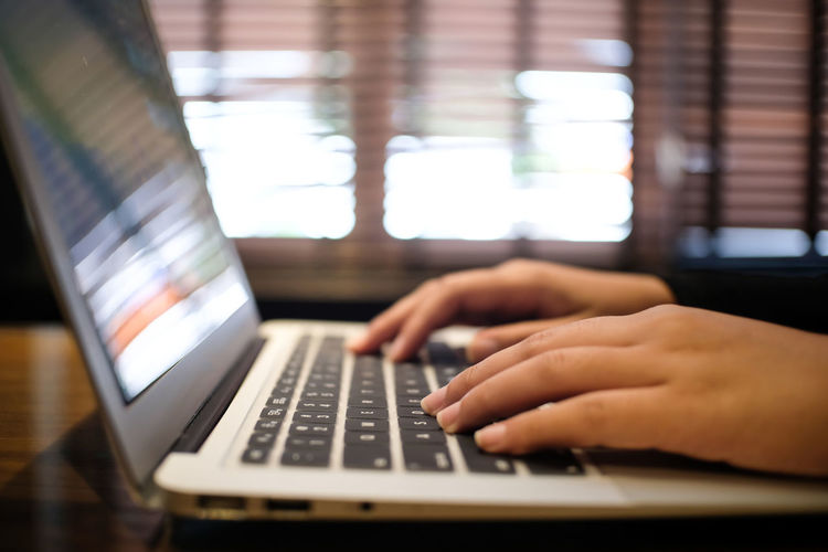 Close-up of hands using laptop