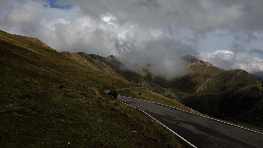 Scenic view of road amidst mountains against sky