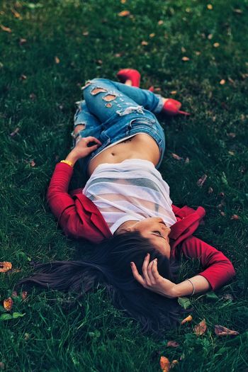 High angle view of fashionable woman lying on grass at park