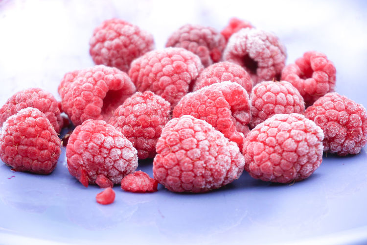 Frozen raspberry on blue plate