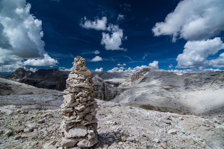 Stone stack on field against mountains