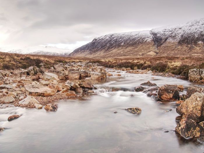 Mystic atmosphere within trek at river etive in glencoe moutains in winter. cold windless winter