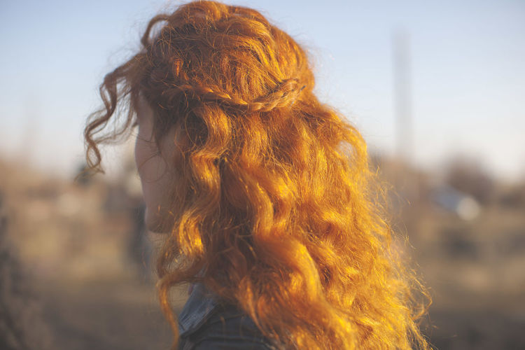 Close-up of woman with curly red hair