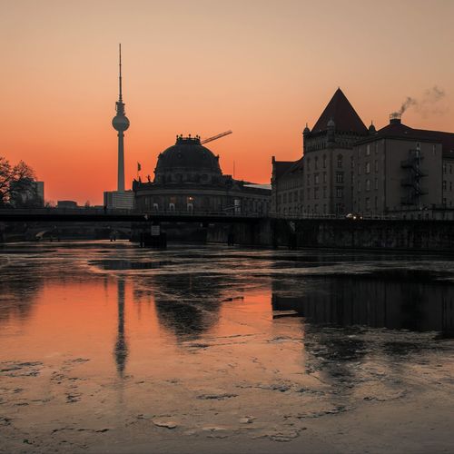 Reflection of buildings in city at sunset