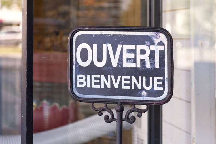 Outdoor open sign with written in it in french ouvert, bienvenue meaning in english open, welcome.
