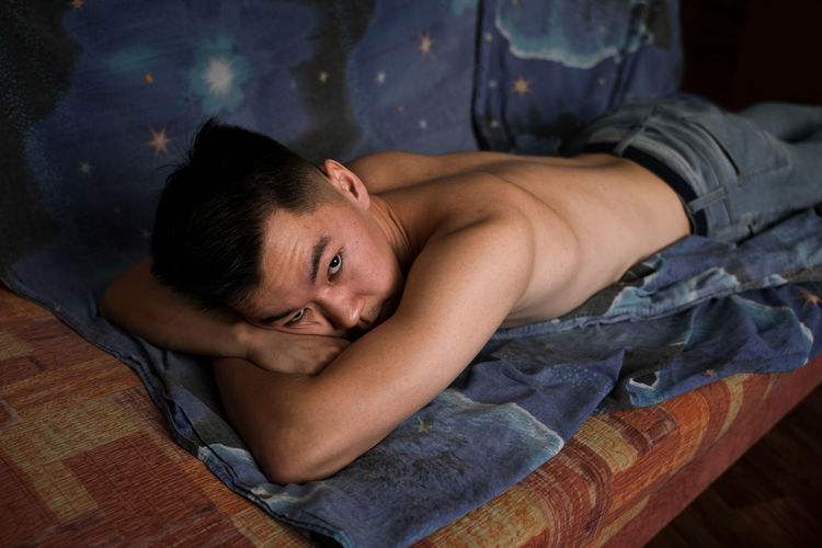 Portrait of woman lying on bed