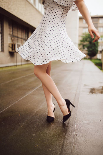 Woman in polka dot dress dancing in the rain