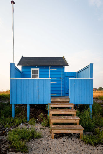 Wooden hut on beach against clear sky