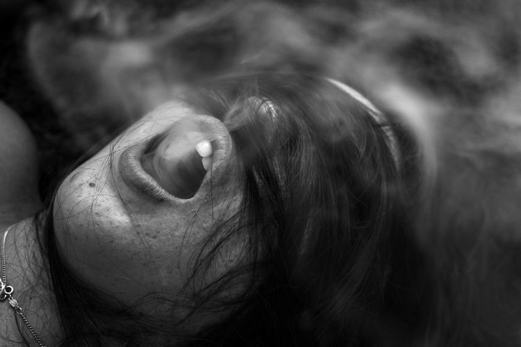 Close-up of young woman exhaling smoke