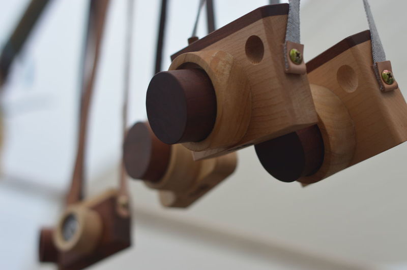 Low angle view of wooden camera toys hanging for sale in store