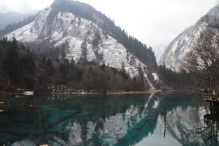 Beatiful landscape of a lake between mountains with reflexion of trees in the water in jiuzhaigou 