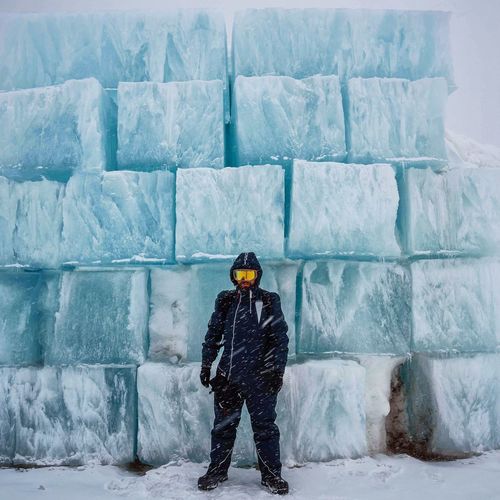 Person in winter clothing with igloo in background