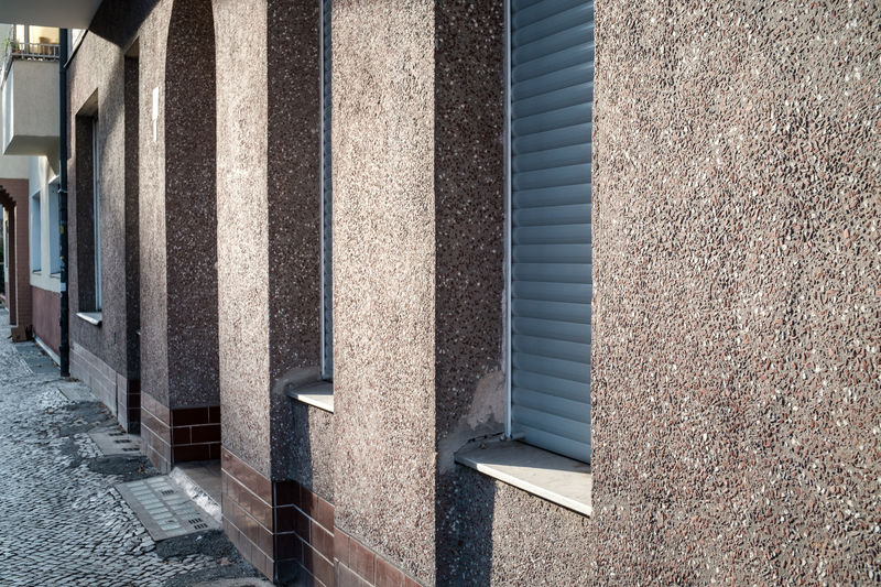 Walls and shuttered doors and windows on a sunny afternoon in the neukölln area of berlin, germany.