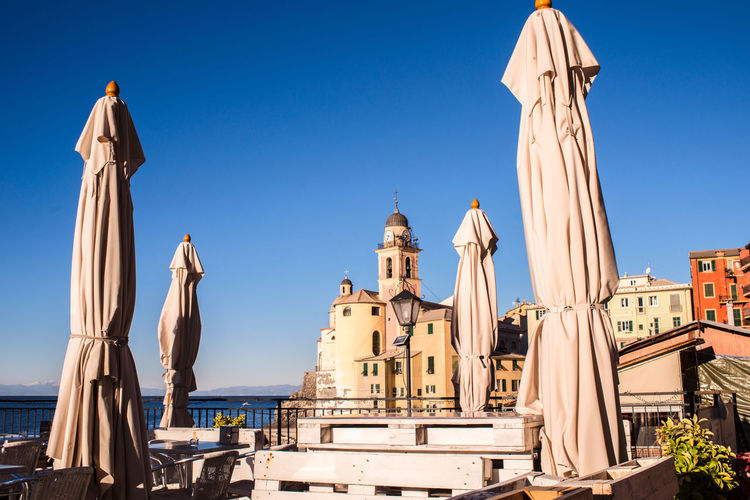 Panoramic view of camogli beach with a castle against blue sky