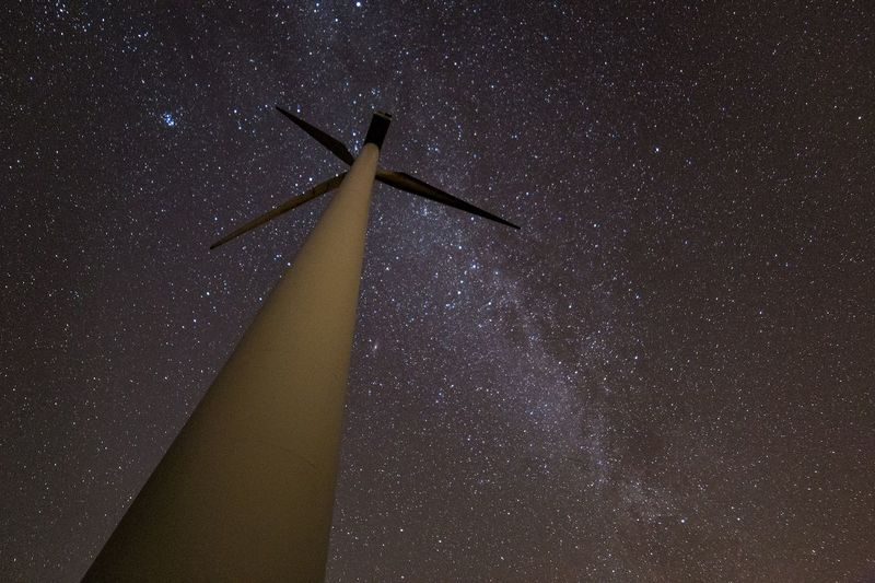 Low angle view of wind turbine at night
