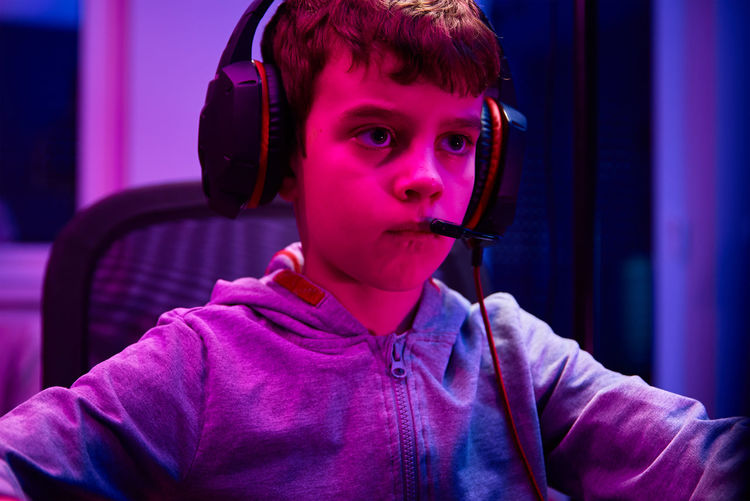 Boy plays computer game at home, gaming addiction