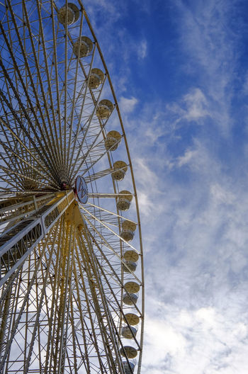 Low angle view of ferris wheel against blue sky