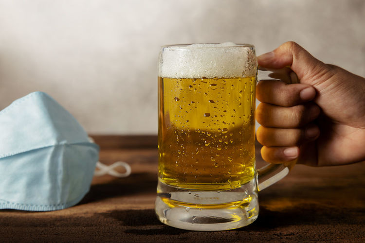 Midsection of man holding beer glass