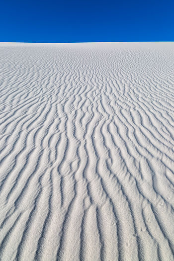 Ripples in white sand dunes against a clear sky, at white sands national park, new mexico