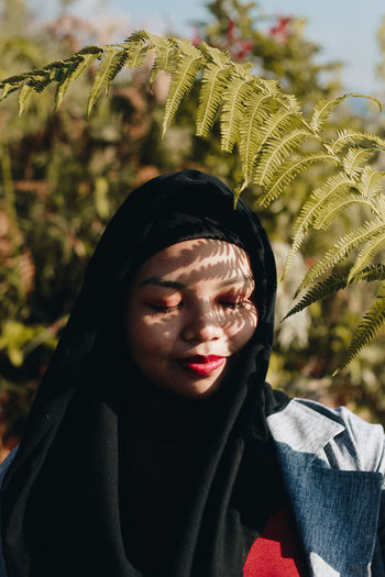 Close-up of woman in hijab against tree